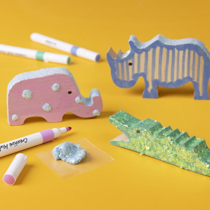 Wooden animals decorated with markers and glitter clay