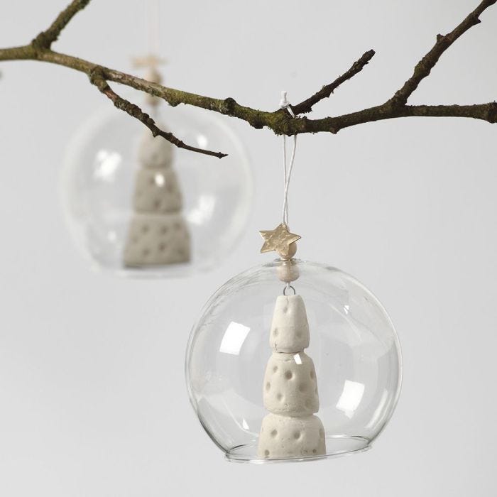 A white Clay Christmas Tree inside a Glass baseless Bauble