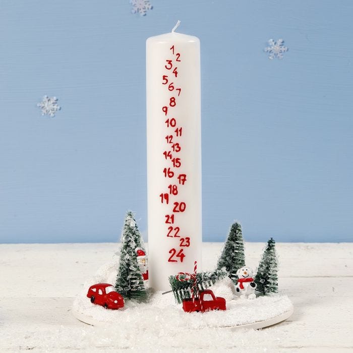 A Decoration with an Advent Candle surrounded by a Miniature Christmas World