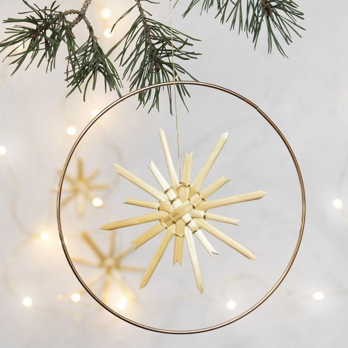 A Straw Star hung in a Metal Hoop