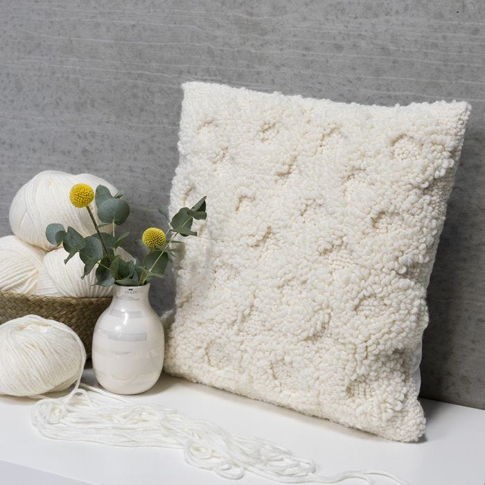 A cushion decorated with a punch needle design