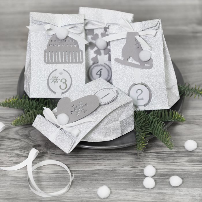 Advent calendar presents decorated with paper decorations and pom-poms