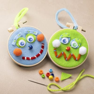 Hanging embroidery decoration with faces