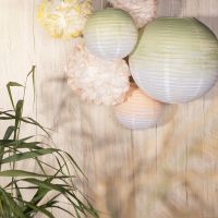 Party decorations from rice paper lamps and paper pom-poms painted with craft paint