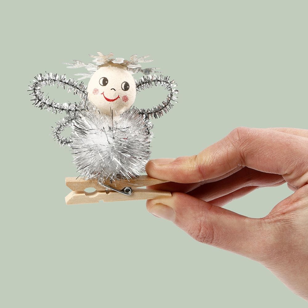 An angel made from a pom-pom and  pipe cleaners on a wooden peg