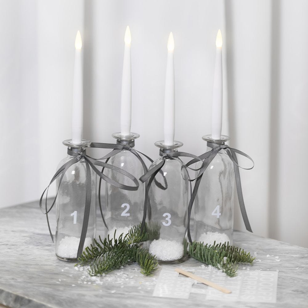 An Advent candle holder from glass bottles with LED candles and rub-on stickers